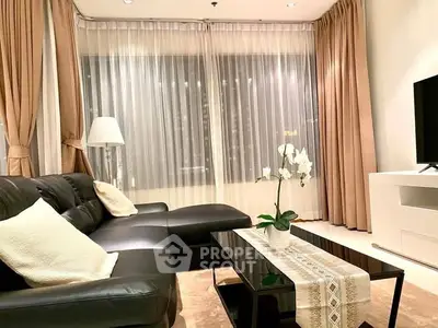 Luxurious living room with elegant decor and large windows in modern apartment.