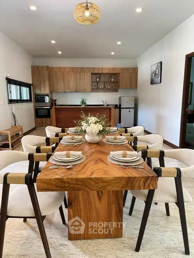 Elegant dining room with wooden table and modern kitchen in open layout