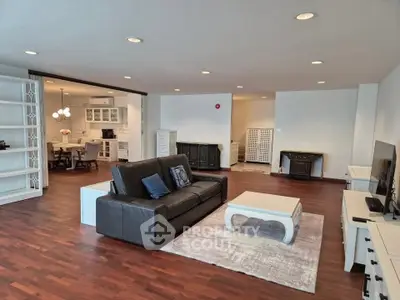 Spacious open-plan living room with elegant hardwood floors and modern furnishings.