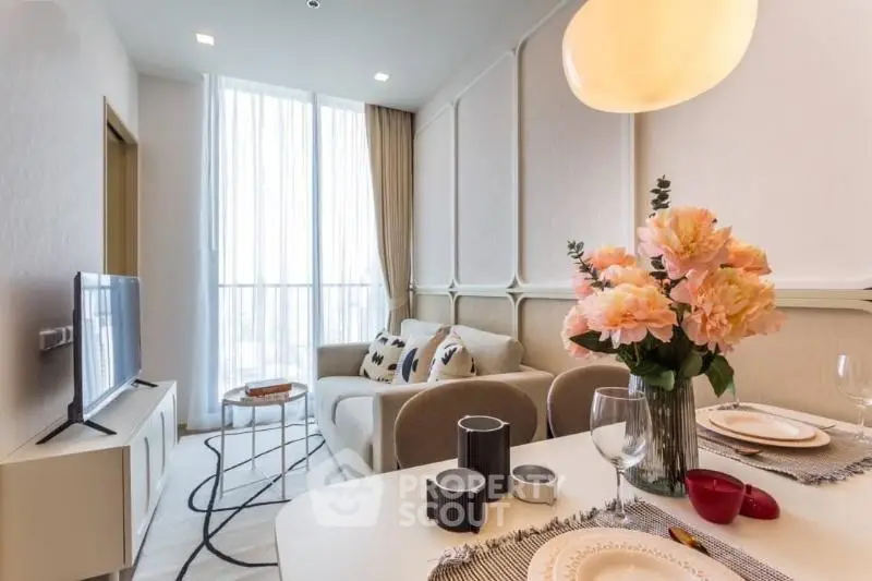 Elegant living room with modern decor and large window, featuring cozy seating and stylish lighting.