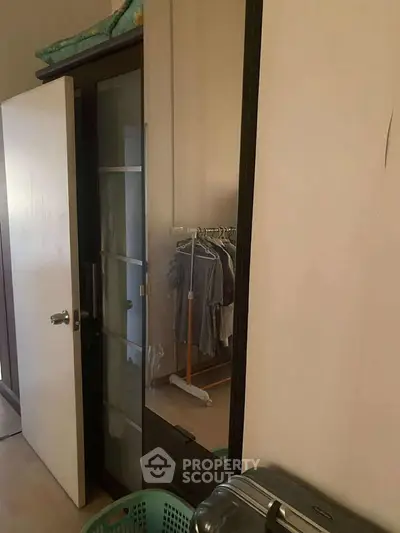 Cozy bedroom with wardrobe and clothes rack, perfect for organized living.