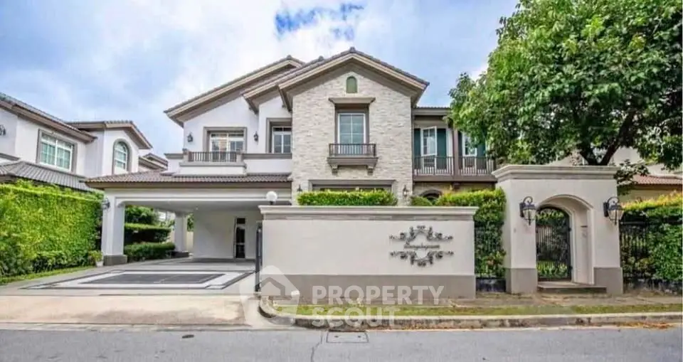 Luxurious two-story house with elegant facade and lush greenery in upscale neighborhood.