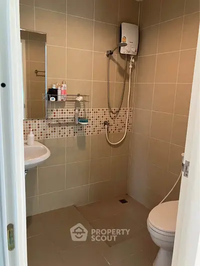Modern bathroom with shower and tiled walls in a real estate property.