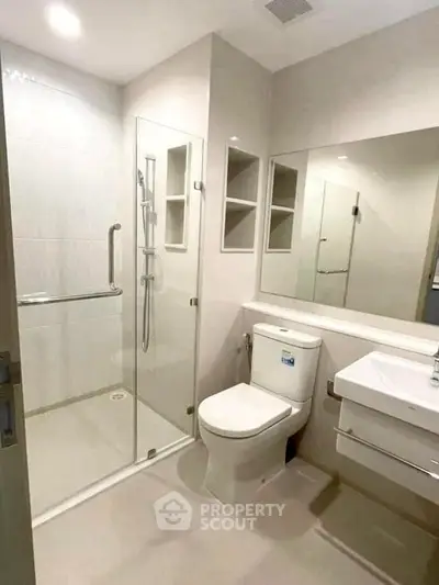 Modern bathroom with glass shower and sleek fixtures in a contemporary home.