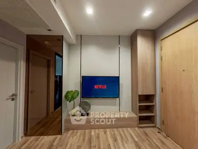 Modern living room with sleek wooden flooring and built-in TV unit, perfect for entertainment.