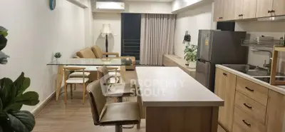 Modern open-layout living room and kitchen with stylish furniture and appliances