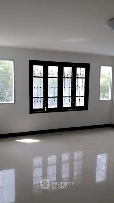 Spacious empty room with large windows and glossy floor