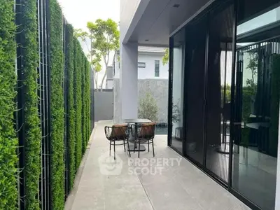 Modern outdoor patio with sleek furniture and lush greenery, perfect for relaxation and entertainment.