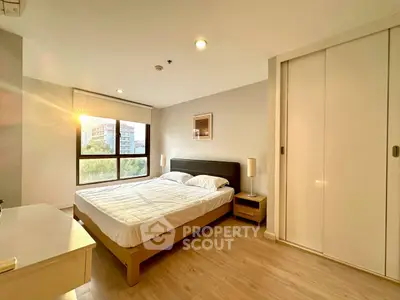 Bright and cozy bedroom with large window and modern furnishings