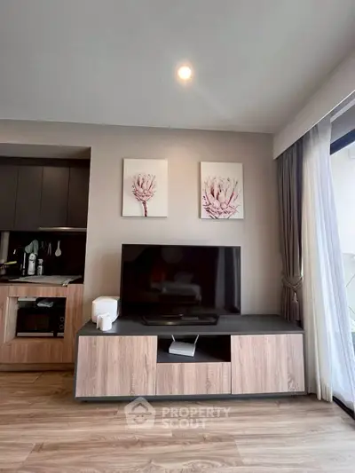 Modern living room with stylish TV stand and floral wall art, featuring sleek wooden flooring and natural light.