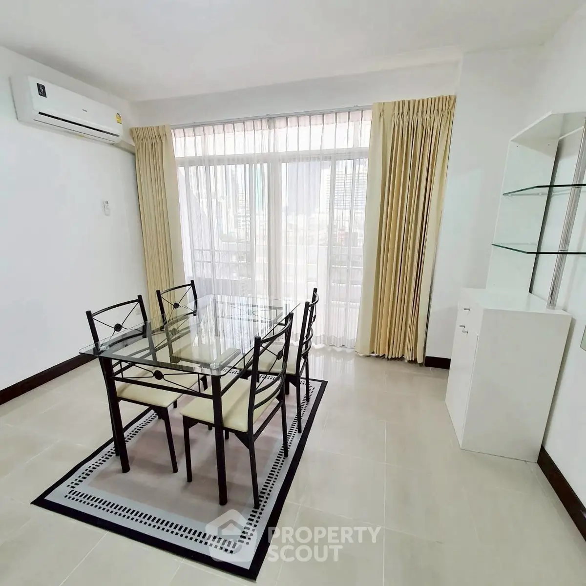 Bright dining area with glass table and modern decor in a spacious apartment.