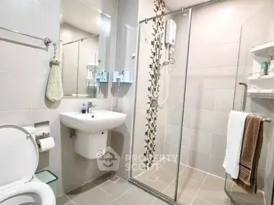 Modern bathroom with glass shower and sleek fixtures in a contemporary apartment.