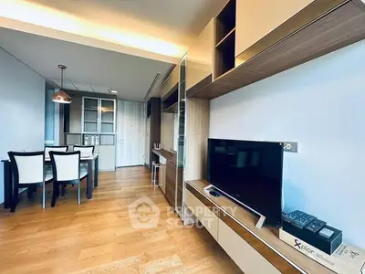 Modern living room with sleek furniture and dining area, featuring a flat-screen TV and stylish decor.