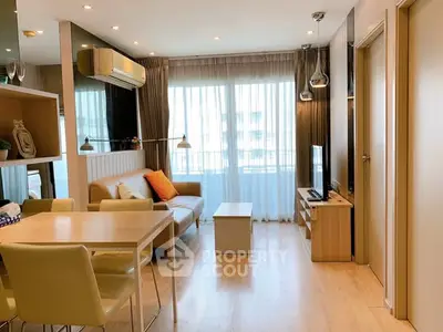 Modern living room with stylish decor and natural light, featuring a cozy seating area and dining space.