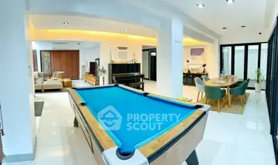 Spacious modern living room with pool table and elegant dining area, perfect for entertainment and relaxation.