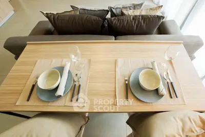 Modern dining setup in stylish living room with elegant tableware and cozy seating.
