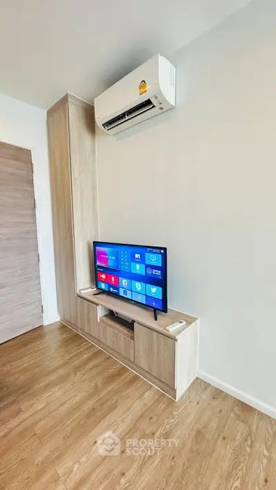 Modern living room with sleek wooden TV stand and wall-mounted air conditioner, perfect for cozy relaxation.