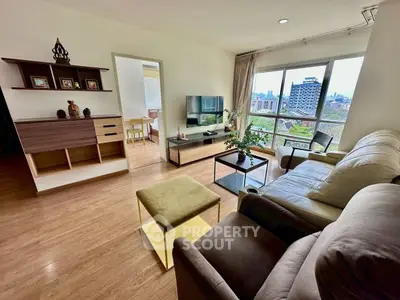 Spacious living room with modern decor and large window offering city views