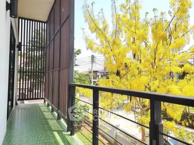 Spacious balcony with vibrant yellow tree view, perfect for relaxation and enjoying nature.