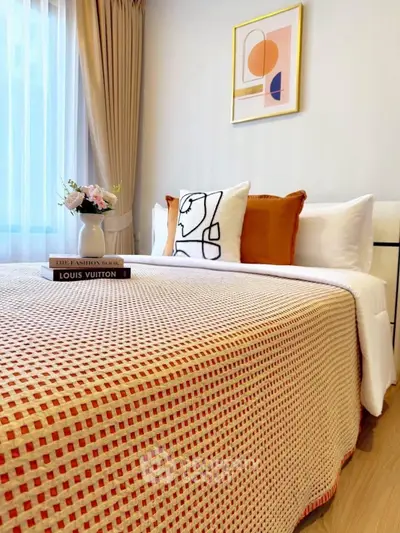 Stylish bedroom with modern decor and cozy bedding in a well-lit apartment.