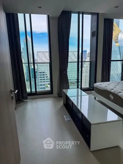 Modern bedroom with floor-to-ceiling windows offering stunning city views