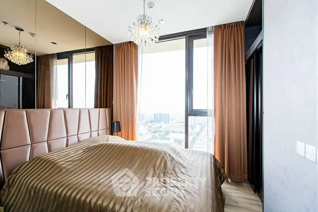 Luxurious bedroom with city view, elegant chandelier, and floor-to-ceiling windows.
