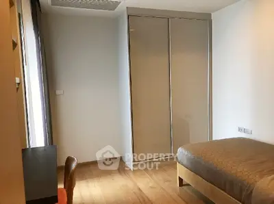 Modern bedroom with wooden flooring and built-in wardrobe, perfect for cozy living.