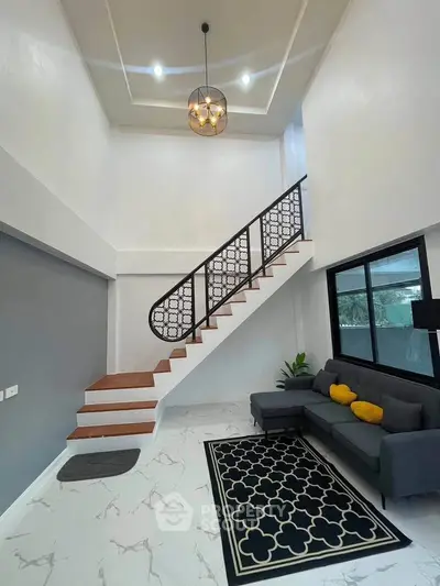 Modern living room with stylish staircase and elegant chandelier