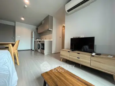 Modern living room with sleek furniture and integrated kitchen appliances in open layout.