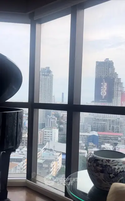 Stunning cityscape view from high-rise apartment with large windows and elegant decor.