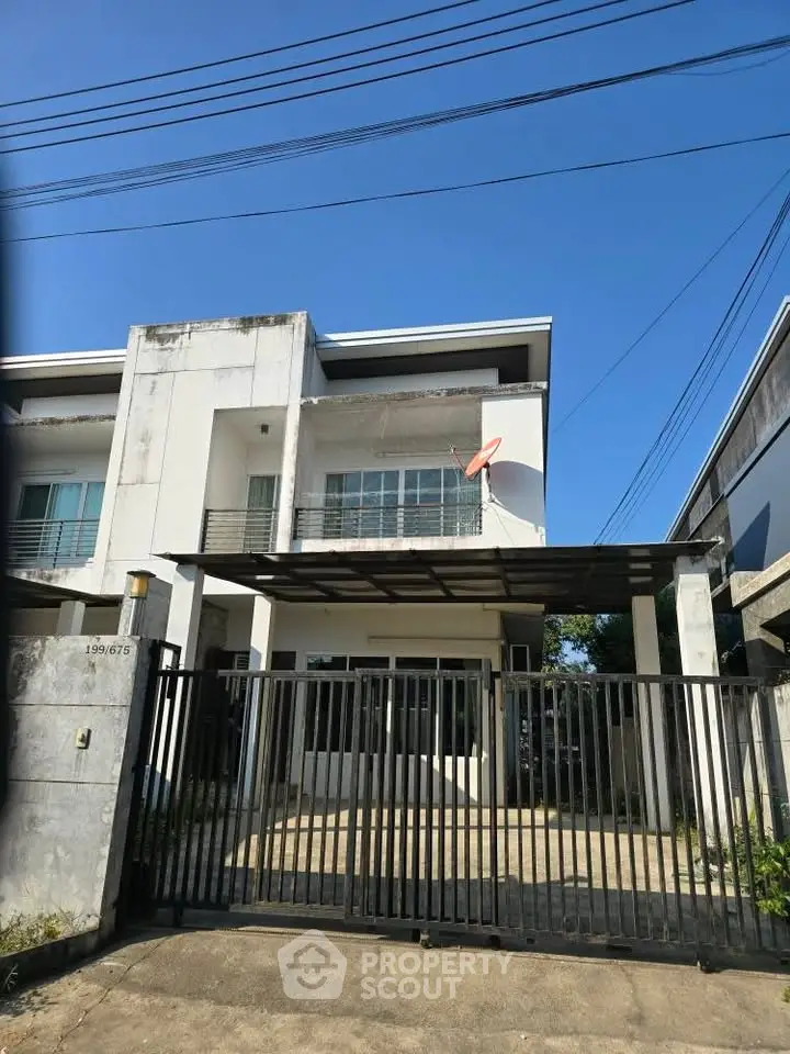 Modern two-story house with gated entrance and balcony, perfect for family living in a suburban neighborhood.