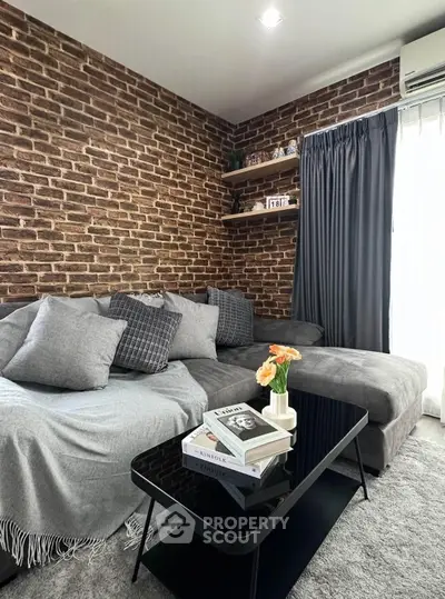 Stylish living room with brick accent wall and cozy gray sectional sofa