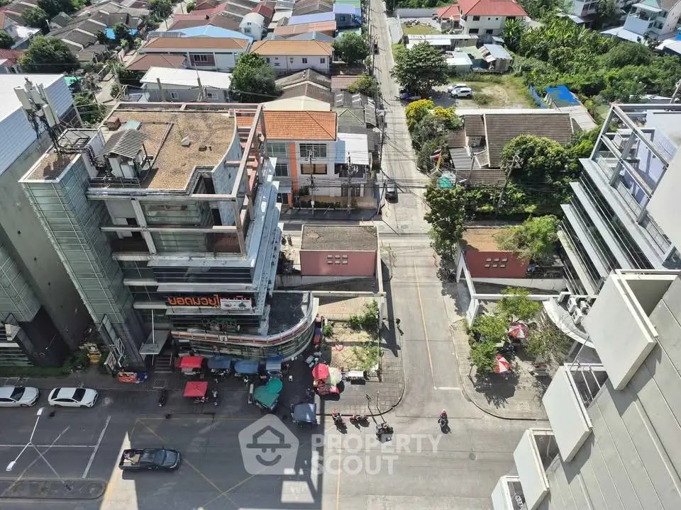 Aerial view of urban neighborhood with modern buildings and street market.