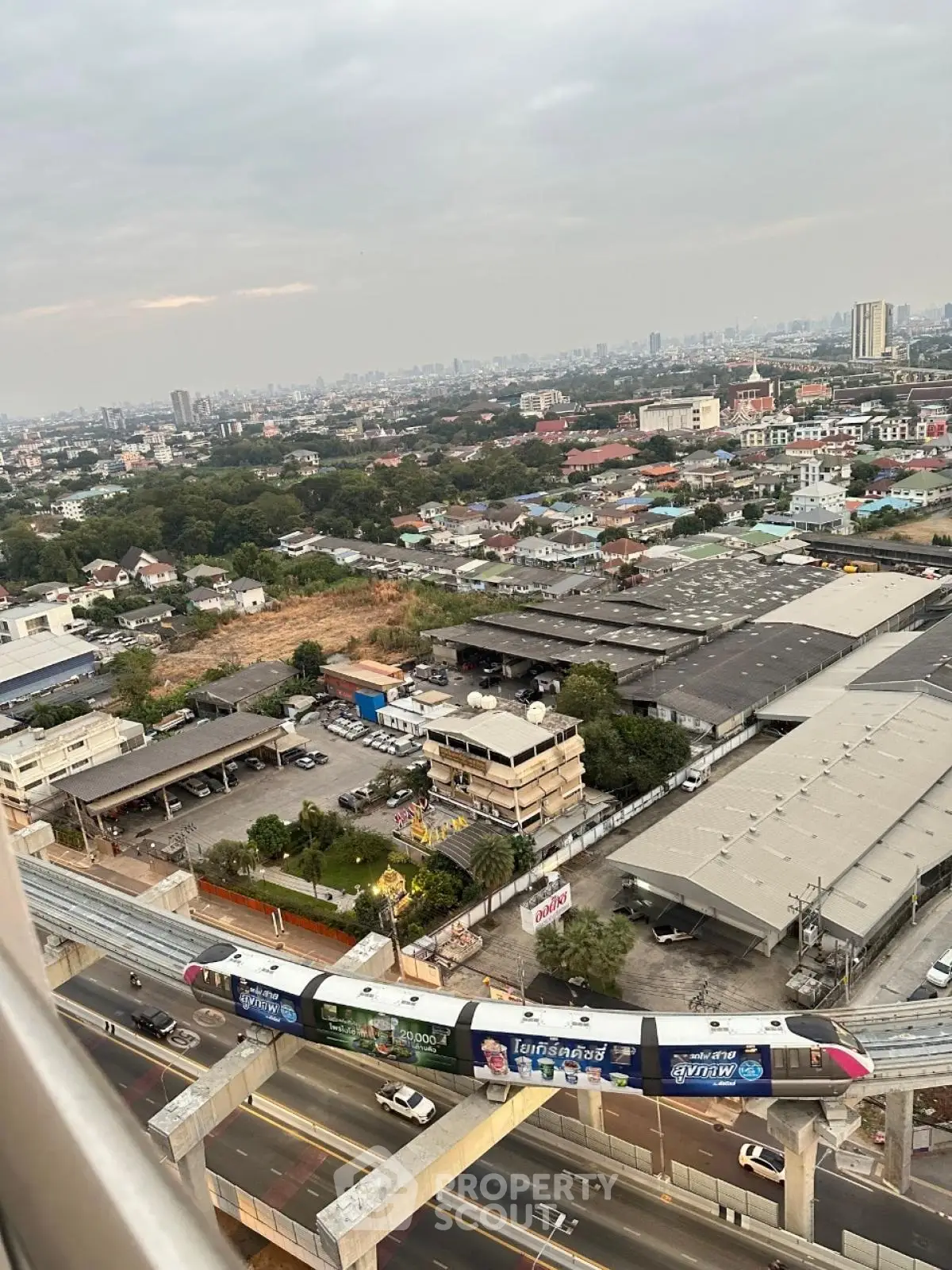 Stunning cityscape view from high-rise building with urban skyline and train in motion.