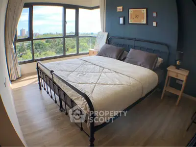 Spacious bedroom with large windows offering a stunning view, featuring a cozy bed and elegant decor.