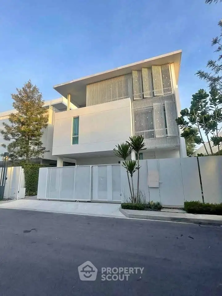Modern minimalist white house with sleek design and lush greenery, perfect for luxury living.