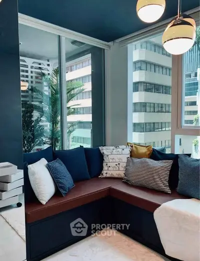 Modern living room with stylish corner seating and large windows offering city views.