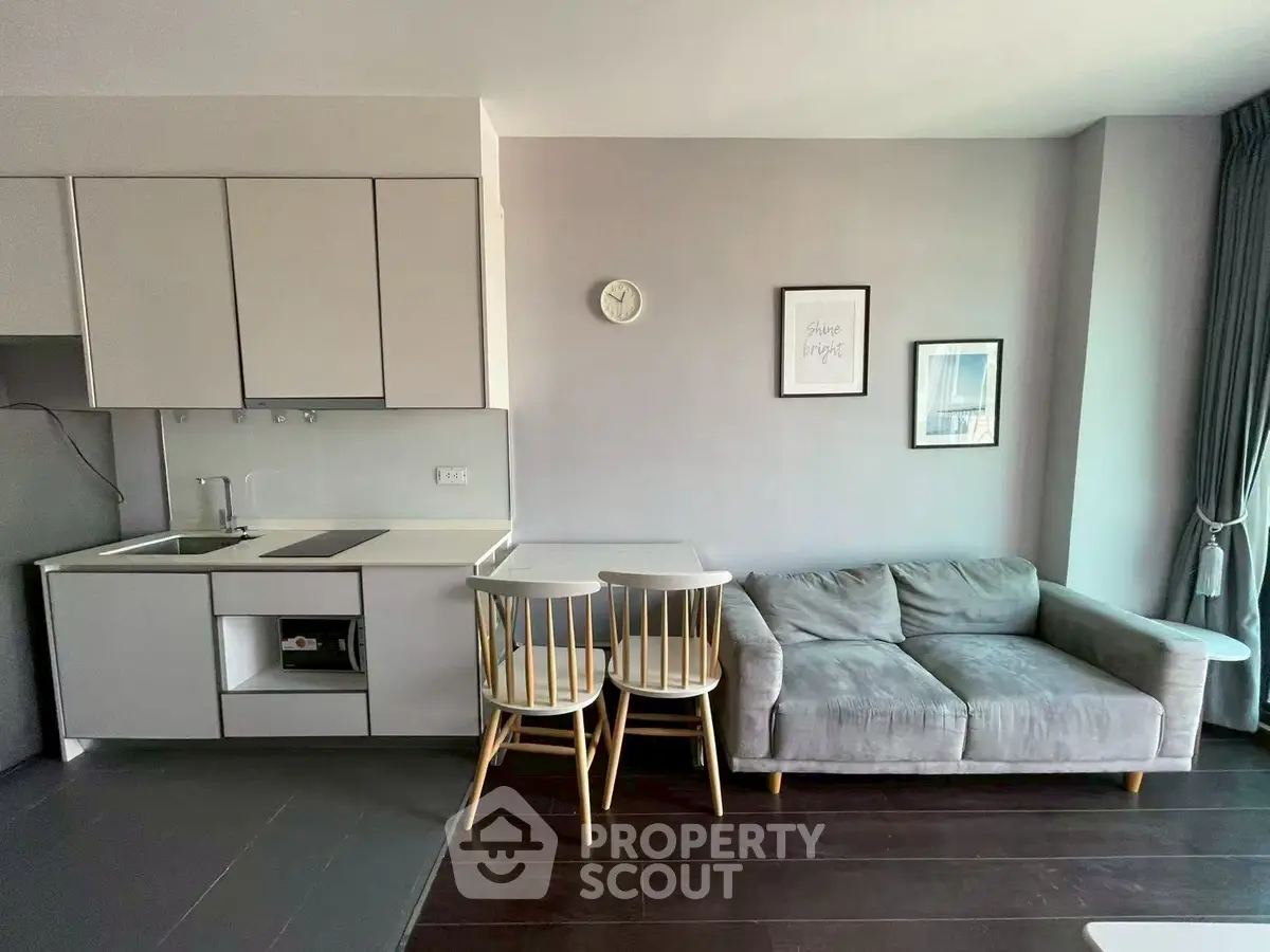 Modern living room with sleek kitchen and cozy sofa, perfect for urban living.