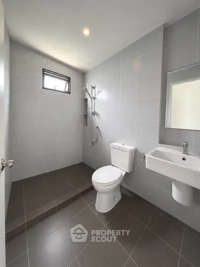 Modern minimalist bathroom with sleek gray tiles and walk-in shower