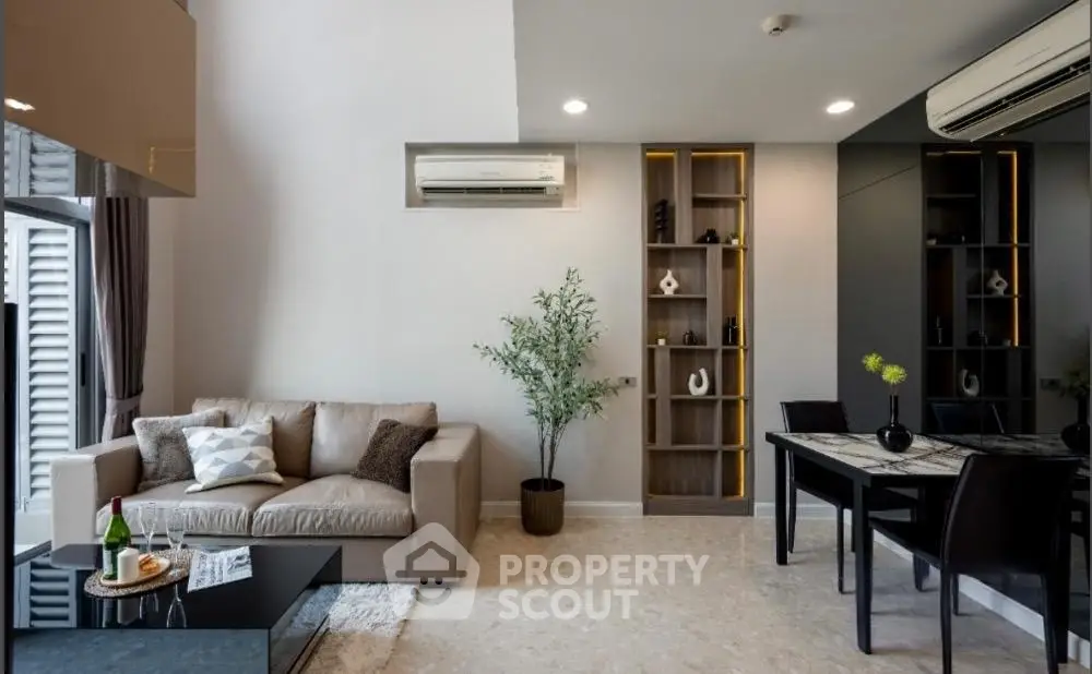 Modern living room with stylish decor and open layout, featuring a cozy sofa and elegant dining area.