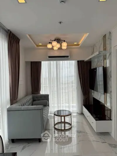 Modern living room with elegant decor and large windows offering natural light.