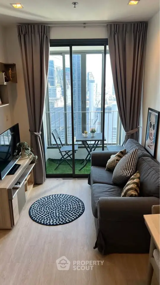 Modern living room with balcony view in urban apartment, featuring stylish decor and cozy seating area.