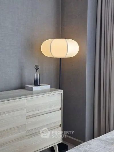 Modern bedroom corner with stylish lamp and wooden dresser