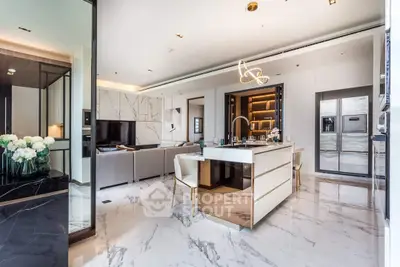 Luxurious open-plan kitchen with marble flooring, modern appliances, and a sleek island in a high-end home.