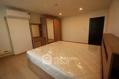 Spacious bedroom with modern wooden furniture and comfortable mattress, ideal for restful nights.