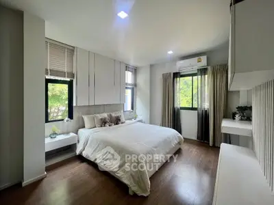 Spacious modern bedroom with large windows and elegant decor, featuring a comfortable bed and stylish furnishings.