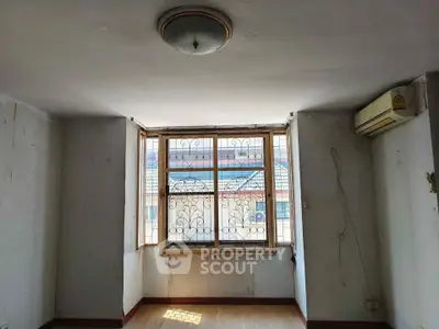 Spacious room with large window and air conditioning, offering potential for customization.