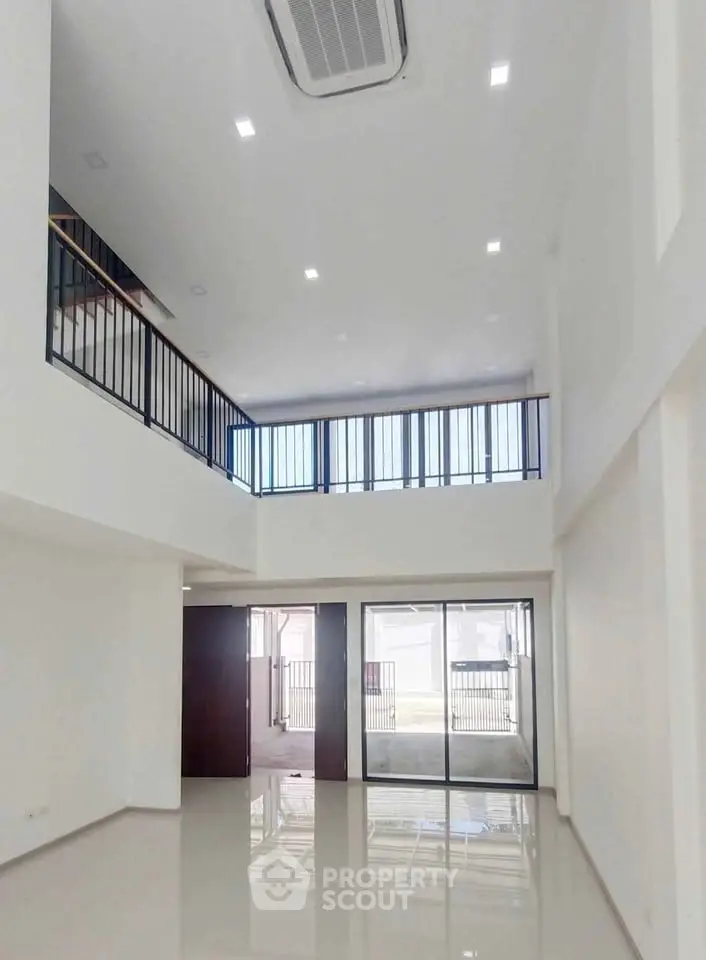 Spacious modern living room with high ceilings and mezzanine level