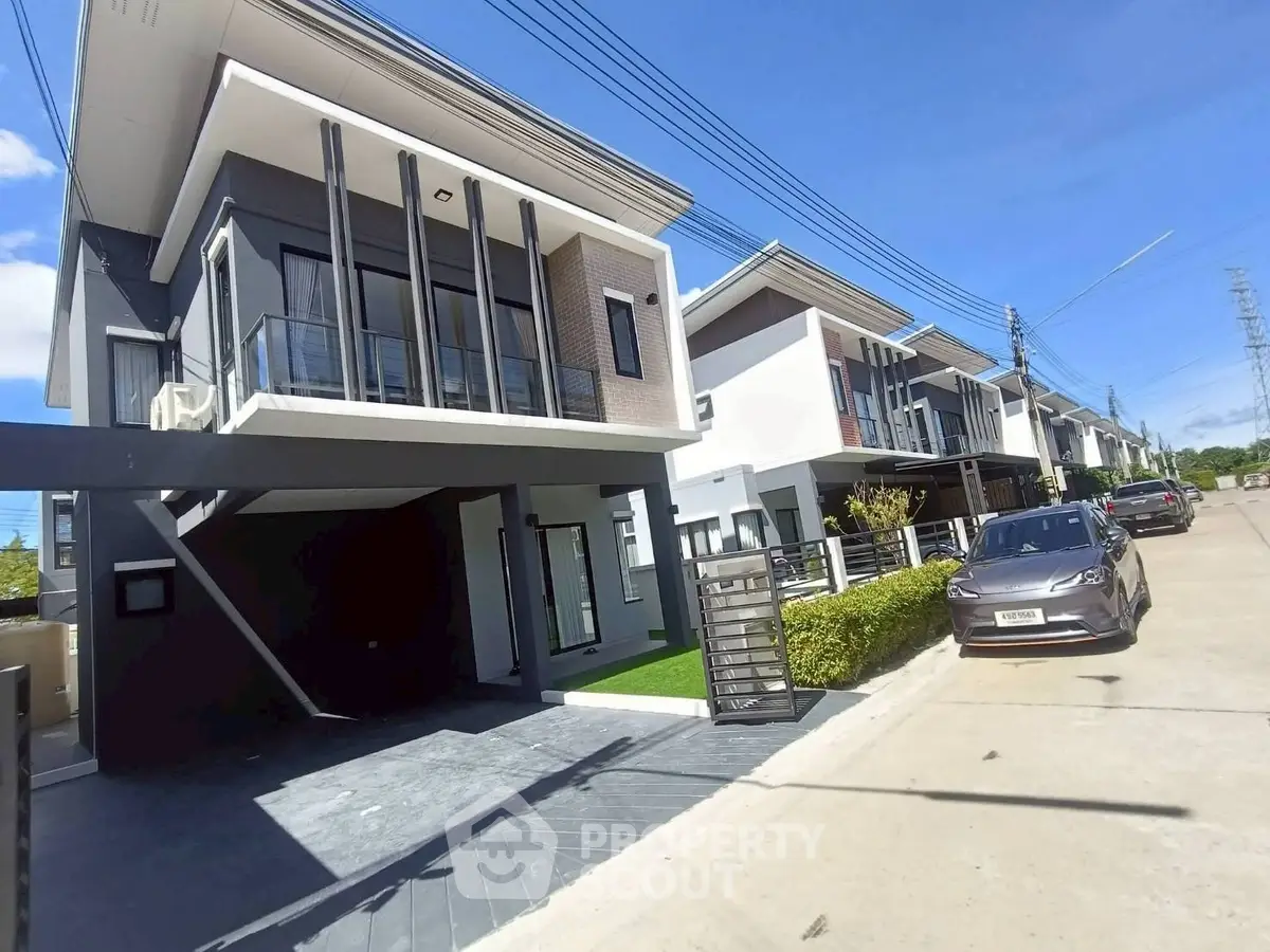 Modern townhouse exterior with sleek design and spacious driveway in a suburban neighborhood.