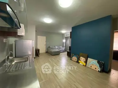 Spacious modern living room with open kitchen and unique wall art
